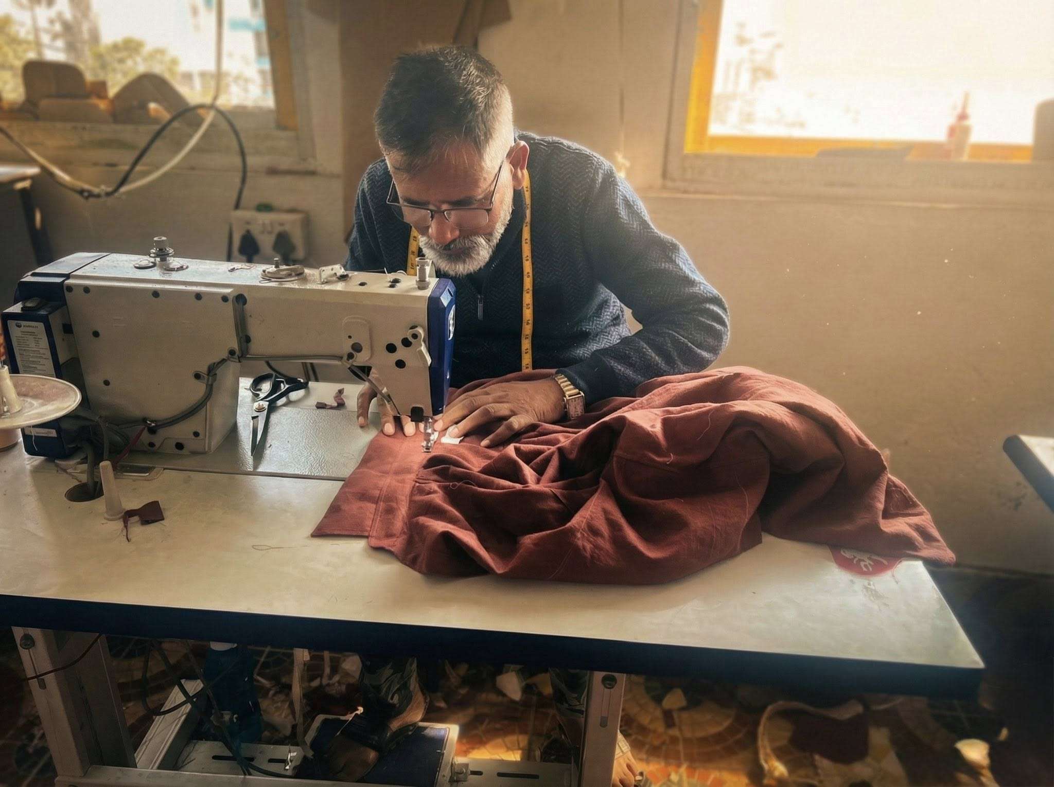nepali man sewing hemp shirt