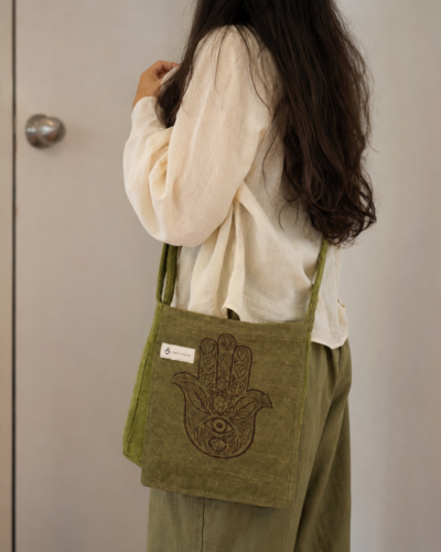 hemp hamsa print side bag carried by a woman
