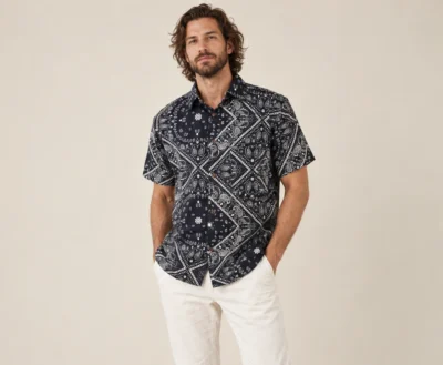 Men’s black mandala hemp short sleeve shirt by Spreadmaya worn by male model, relaxed front pose on beige background.