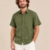 Relaxed view of men’s green short sleeve hemp shirt by Spreadmaya worn by male model on beige background.