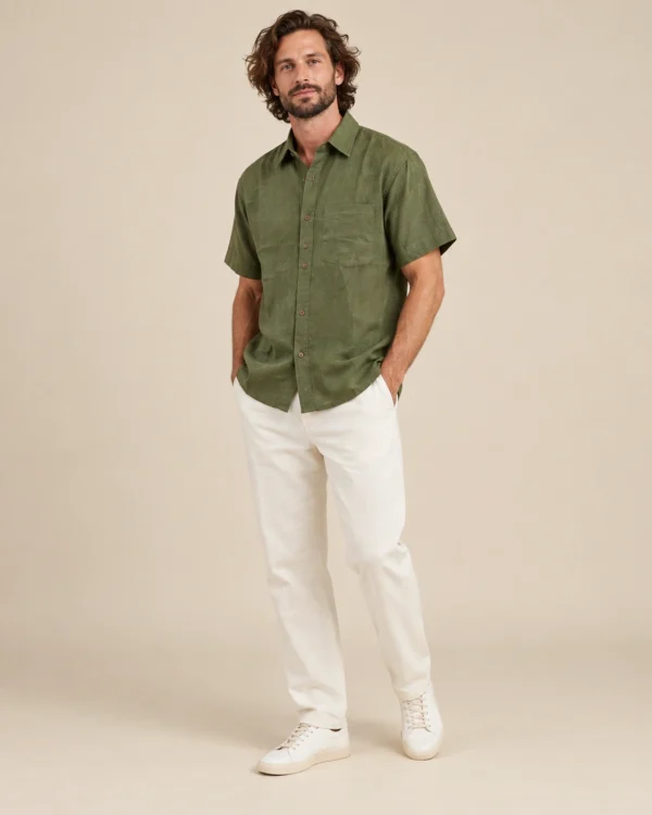 Relaxed view of men’s green short sleeve hemp shirt by Spreadmaya worn by male model on beige background.
