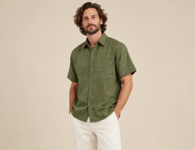 Relaxed view of men’s green short sleeve hemp shirt by Spreadmaya worn by male model on beige background.