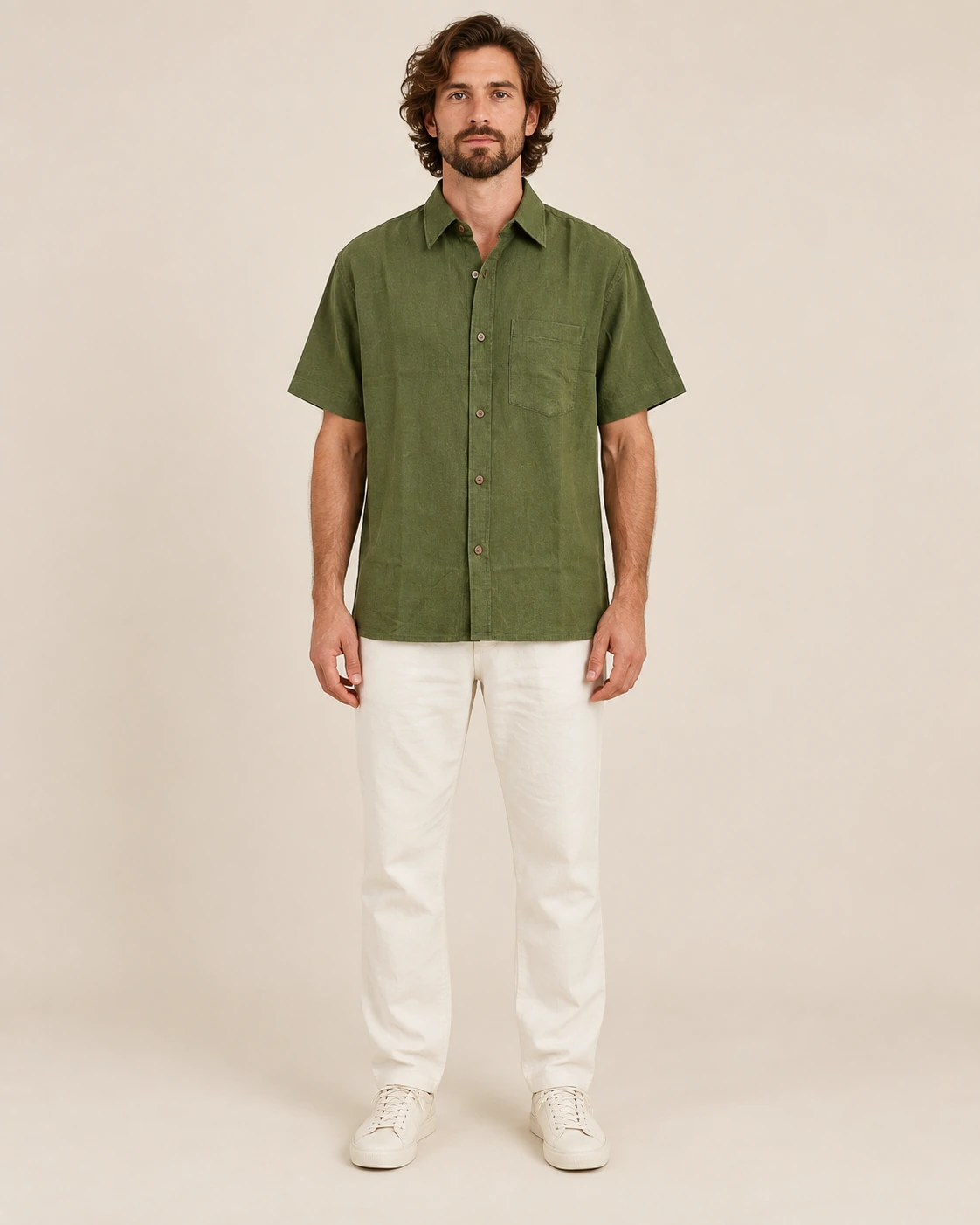 Front view of men’s olive green hemp short sleeve shirt by Spreadmaya worn by male model on beige background.