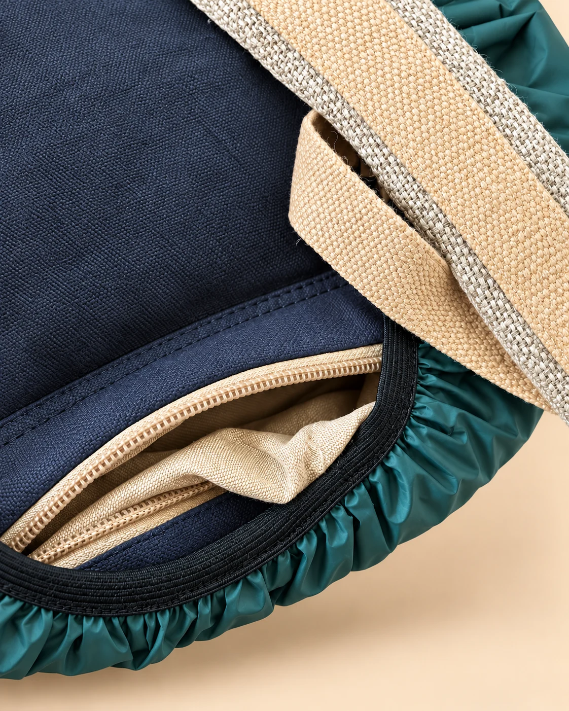 Hidden bottom compartment of SpreadMaya hemp maternity backpack containing a teal rain cover with elastic edging.