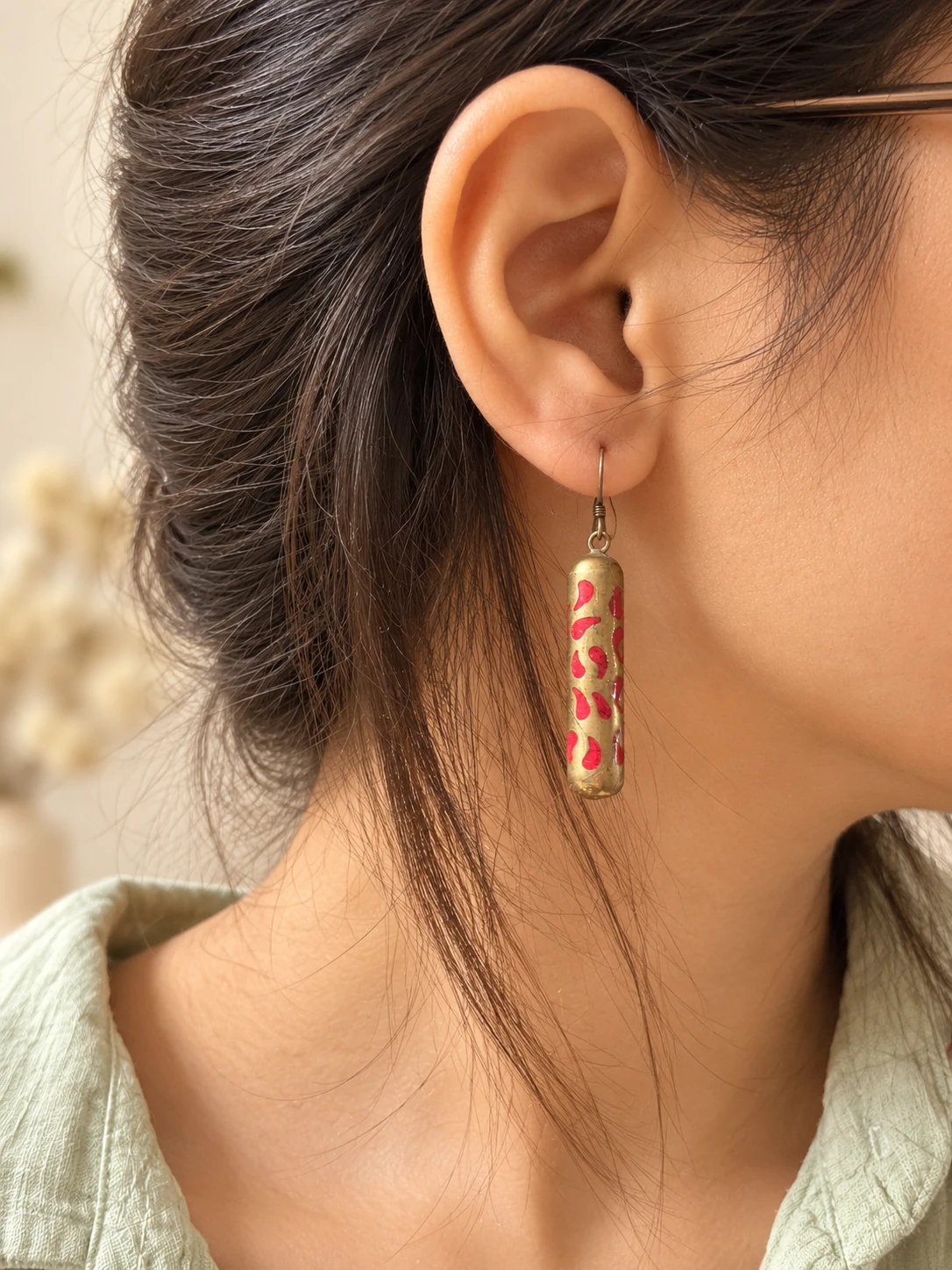 paisley cylinder earring worn by a woman
